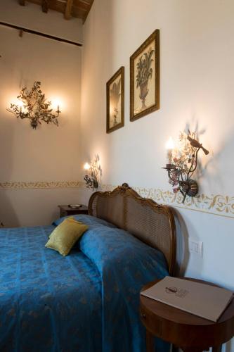 a bedroom with a blue bed and a table at Palazzo Pacini in Colle Val D'Elsa