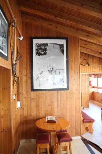 a room with a wooden wall with a table and chairs at Hôtel Bruxelles in Soldeu