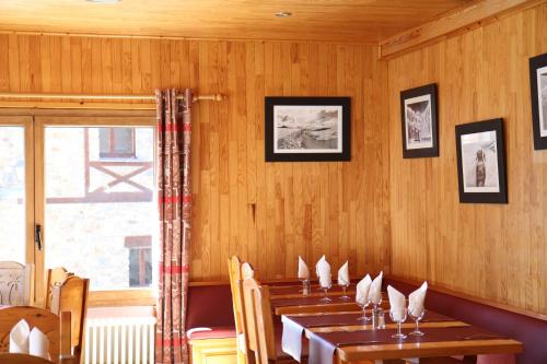 a dining room with wooden walls and wooden tables at Hôtel Bruxelles in Soldeu