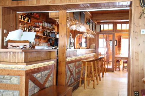 a bar in a restaurant with wooden walls and wooden stools at Hôtel Bruxelles in Soldeu