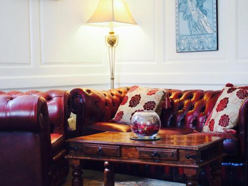 a living room with a leather couch and a table at Wrangham House in Filey