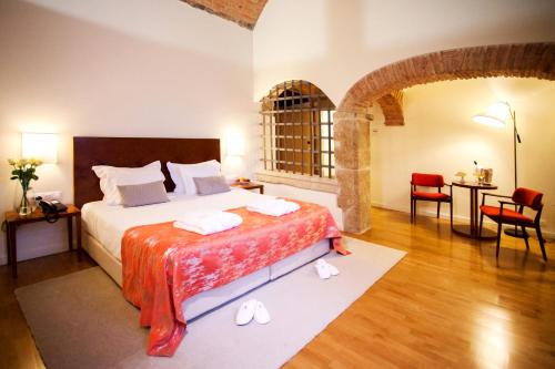 um quarto com uma cama, uma mesa e cadeiras em Convento Da Serta Hotel na Sert