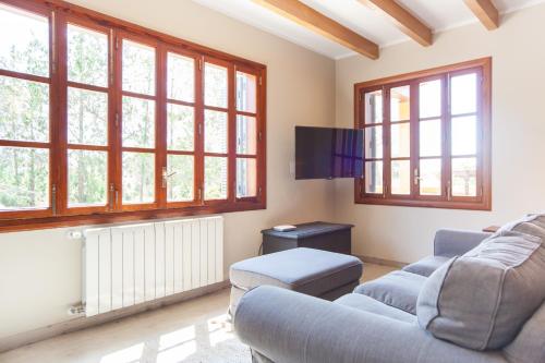 a living room with two couches and windows at Finca Can Pol in Inca