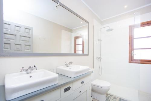 a white bathroom with two sinks and a mirror at Finca Can Pol in Inca