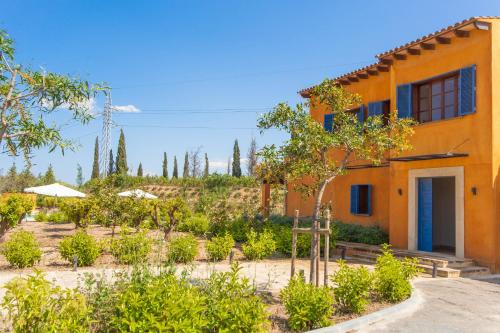 an orange building with a garden in front of it at Finca Can Pol in Inca