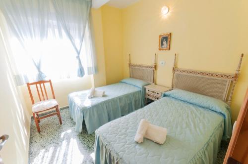Playa de MiramarにあるPandora 3のベッドルーム1室(ベッド2台、椅子、窓付)