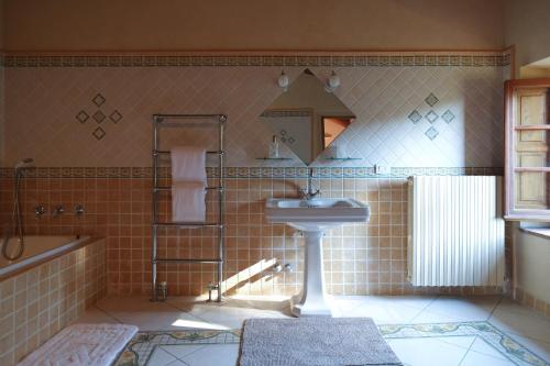 ein Badezimmer mit einem Waschbecken, einem Spiegel und einer Badewanne in der Unterkunft Tenuta La Novella in Poggio Alla Croce
