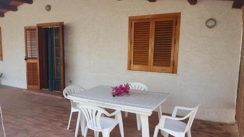 una mesa y sillas frente a una casa en Villa CapoAranciotto, en Cefalú