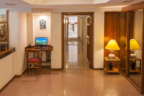 a hallway with a desk and a computer on a table at Hotel Princess in Mendoza
