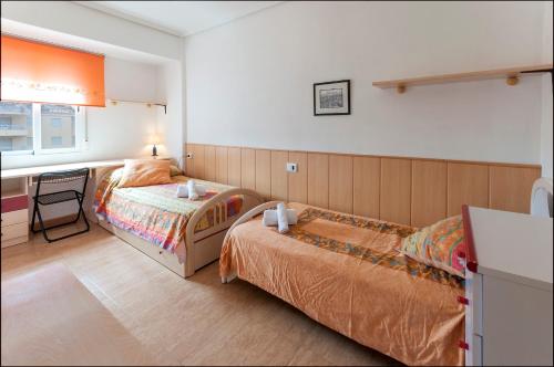 La Playa de la Torre de PilesにあるOdiseaのベッドルーム1室(ベッド2台、テーブル、窓付)