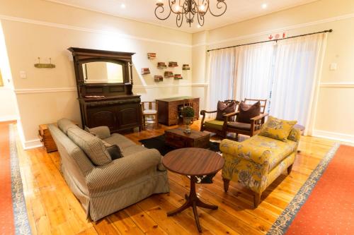 a living room with a couch and chairs and a television at Royal St. Andrews Hotel, Spa and Conference Centre in Port Alfred