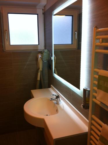 a bathroom with a sink and a mirror at Hotel Meida in Pozza di Fassa