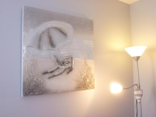 a painting of a chair with an umbrella at Chez Augustin in Lacanau-Océan