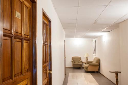 a corridor of a hospital with chairs and a door at Hotel Princess in Mendoza