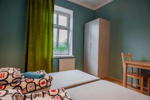 a small bedroom with two beds and a window at Atlantis Hostel in Kraków