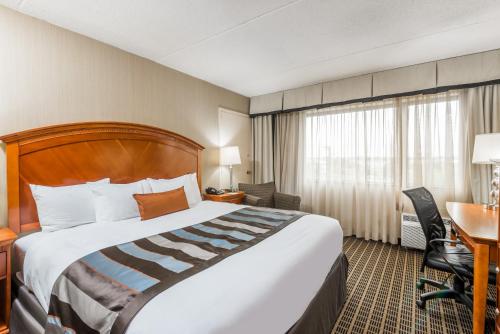 a hotel room with a large bed and a desk at Wingate by Wyndham Springfield in Springfield