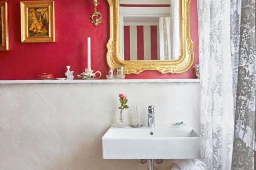a bathroom with a white sink and a mirror at La Zarabba Boutique Hotel in Ponti Sul Mincio