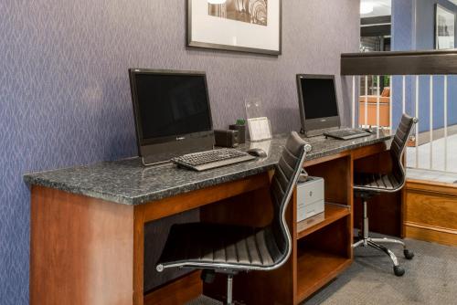 an office with two computers on a desk with chairs at Wingate by Wyndham Springfield in Springfield