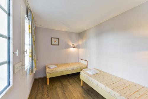 een kamer met 2 bedden en een raam bij Residence Cap Glenan - maeva Home in Bénodet