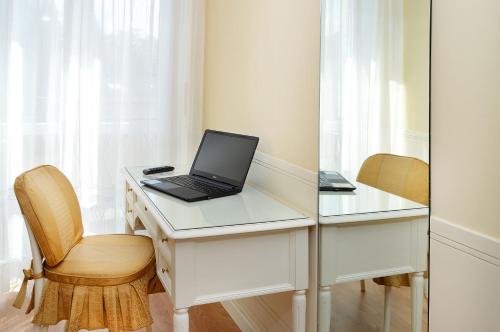 a desk with a laptop computer on top of it at Ambasciatori Palace in Montecatini Terme