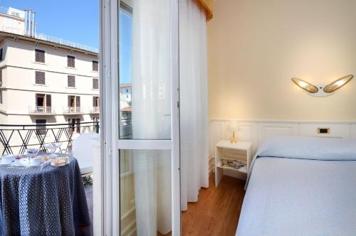 a bedroom with a bed and a view of a building at Ambasciatori Palace in Montecatini Terme