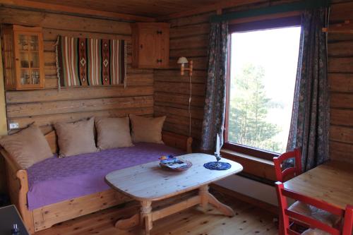 a room with a bed and a table in a cabin at Kvila Hytteutleie in Garmo