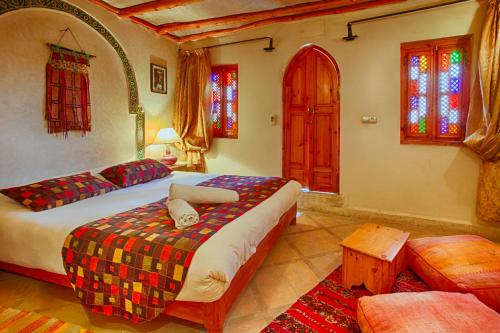 a bedroom with two beds and stained glass windows at Riad Kenzo in Marrakesh