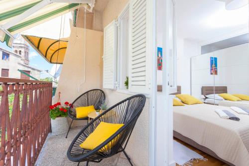 a balcony with two chairs and a bed and a bedroom at Apartment Mikula in Makarska