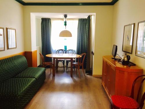 マドンナ・ディ・カンピリオにあるResidence Hotel Sport Campiglioのリビングルーム(テーブル、緑のソファ付)