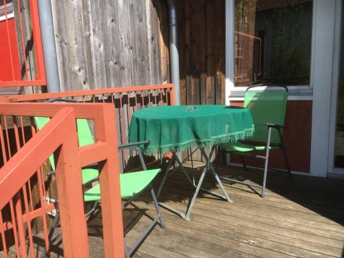 a green table and chairs on a porch at Apartmentanlage am Kellerberg in Zandt
