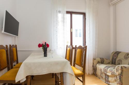 un comedor con una mesa con un jarrón de flores. en Villa Anka, en Cavtat