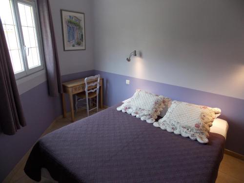 a bedroom with a bed with two pillows on it at Au Relais Provencal in Bagnols-en-Forêt