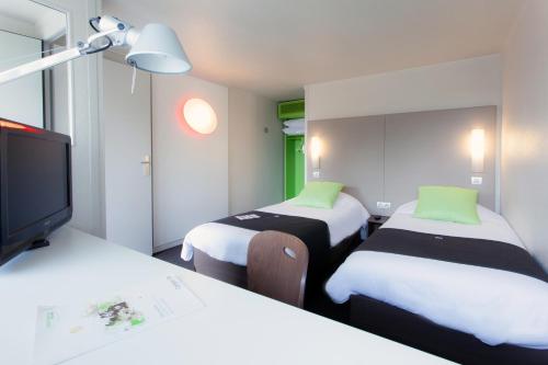 Cette chambre comprend 2 lits et une télévision à écran plat. dans l'établissement Campanile Saint-Malo ~ Saint-Jouan-Des-Guerets, à Saint-Jouan-des-Guérets