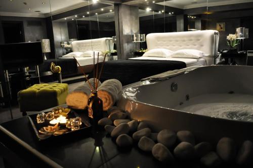 a bathroom with a bath tub and a room with a bed at Andromeda Hotel Thessaloniki in Thessaloniki