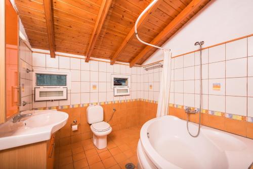 een badkamer met een bad, een toilet en een wastafel bij Argo Poolside in Benitses