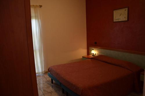 Savignano sul Panaroにあるホテル フォーマイカのベッドルーム1室(ベッド1台、テーブルの上にランプ付)