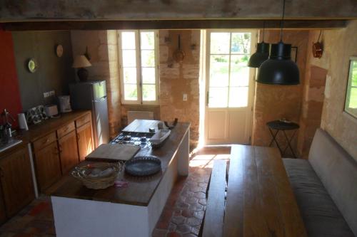 - une cuisine avec une table et une cuisinière dans l'établissement Maison de Bastien, à Lugon et l’Ile du Carney