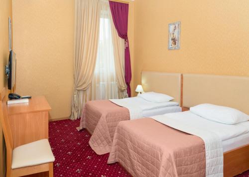 um quarto de hotel com duas camas e uma janela em Lermontovskiy Hotel em Odessa