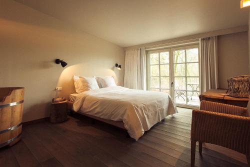 a bedroom with a bed and a large window at Sparhof in Dranouter