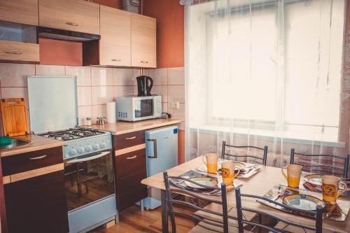 Viktoria Apartment في نارفا: مطبخ مع طاولة مع كراسي وميكروويف