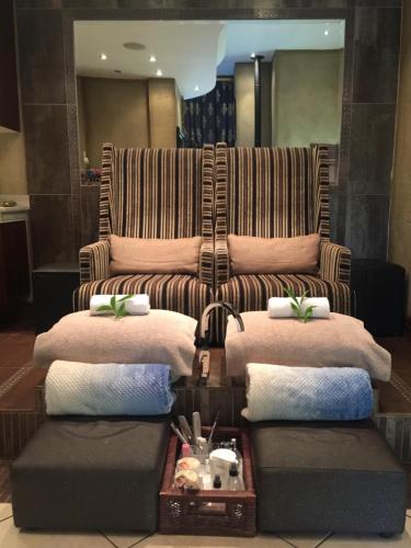 a living room with a couch and four pillows at Witwater Guest House & Spa in Kempton Park