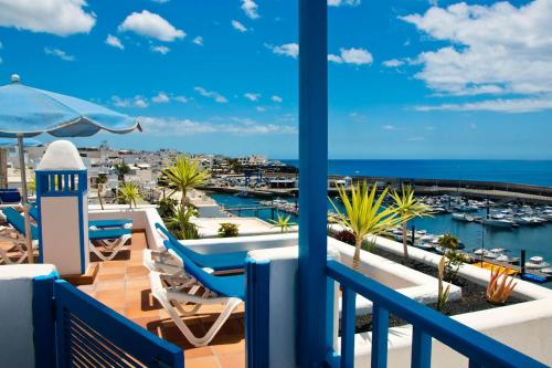 a balcony with chairs and a view of the marina at Apartamentos Agua Marina in Puerto del Carmen