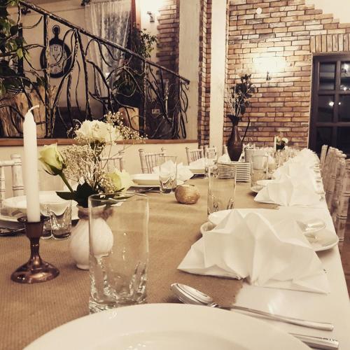 a table with white plates and napkins on it at Zajazd Złota Rybka in Andrychów