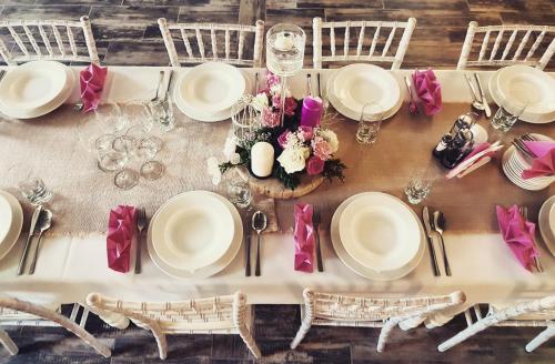 - une table avec des assiettes et des chaises blanches et des fleurs dans l'établissement Zajazd Złota Rybka, à Andrychów