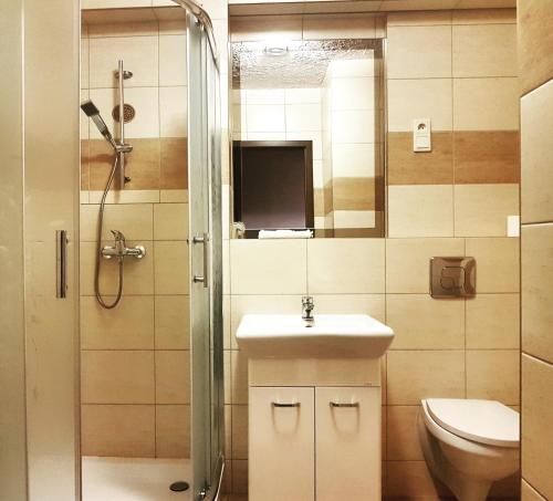 La salle de bains est pourvue d'une douche, d'un lavabo et de toilettes. dans l'établissement Zajazd Złota Rybka, à Andrychów