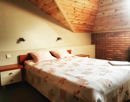 1 dormitorio con 1 cama grande y techo de madera en Zajazd Złota Rybka en Andrychów