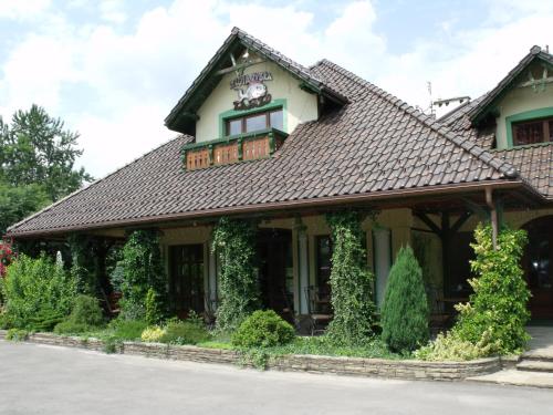 een huis met een betegeld dak bij Zajazd Złota Rybka in Andrychów