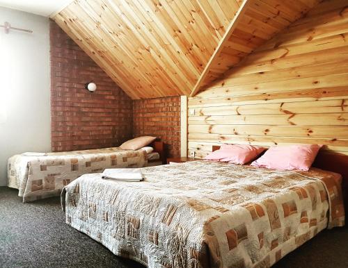 a bedroom with two beds and a wooden ceiling at Zajazd Złota Rybka in Andrychów