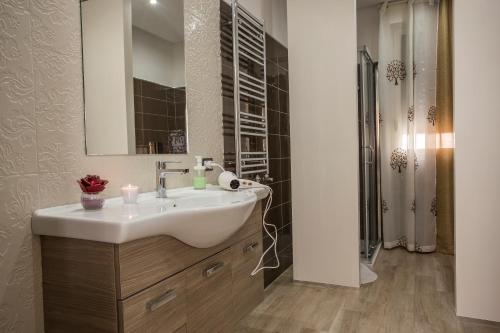 a bathroom with a white sink and a shower at House Etna View in Mascali