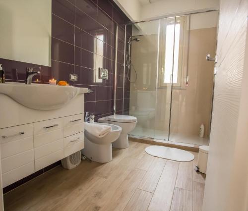 a bathroom with a sink and a toilet and a shower at House Etna View in Mascali